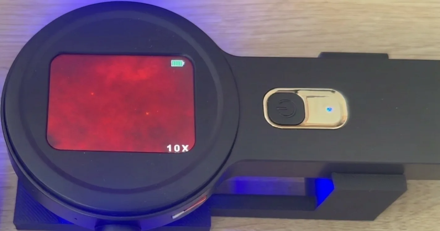 Microscope view with microplastic particles — faint glowing dots on the red field (example 6)