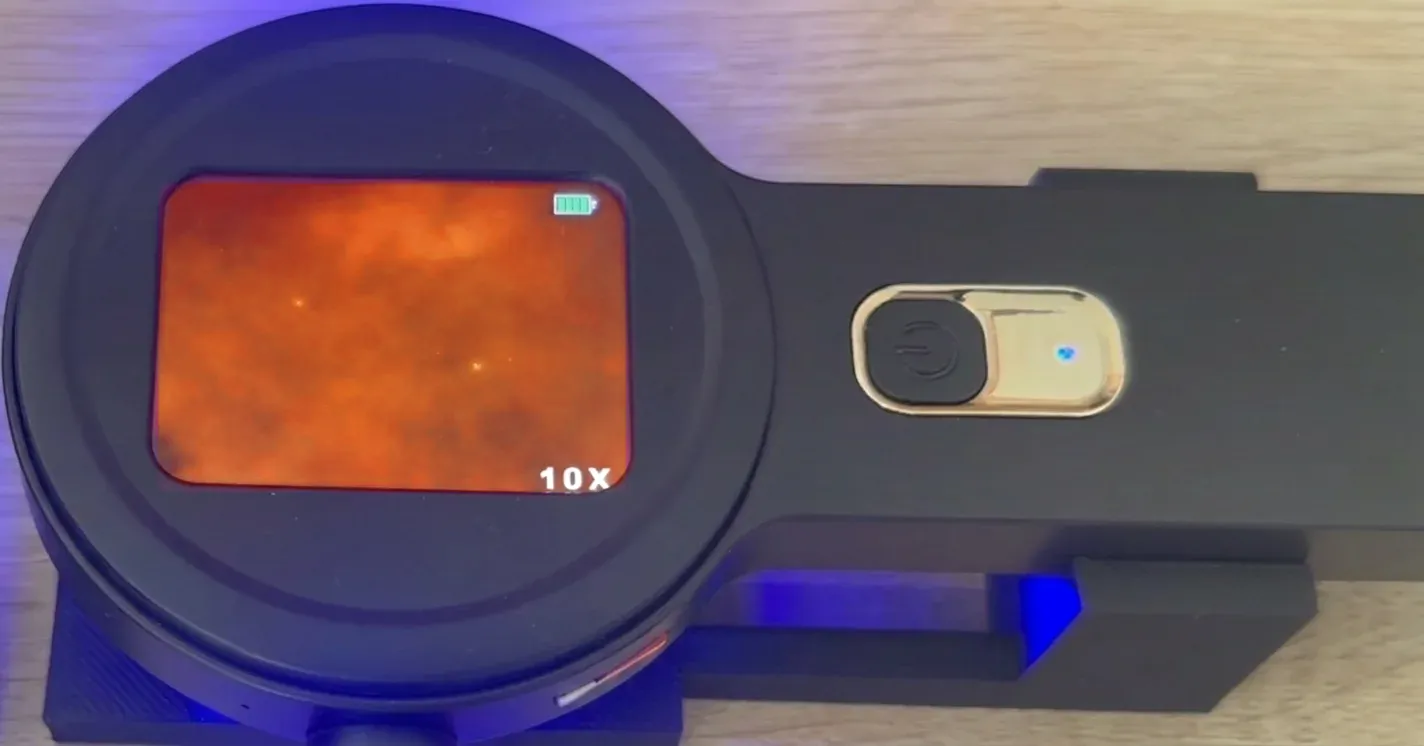 A second microscope view with particles on a warmer, orange background