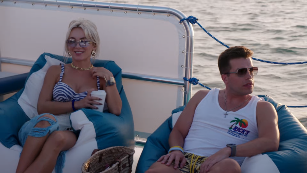 Yara Zaya and Jovi Dufren sit on a yacht on the ocean.