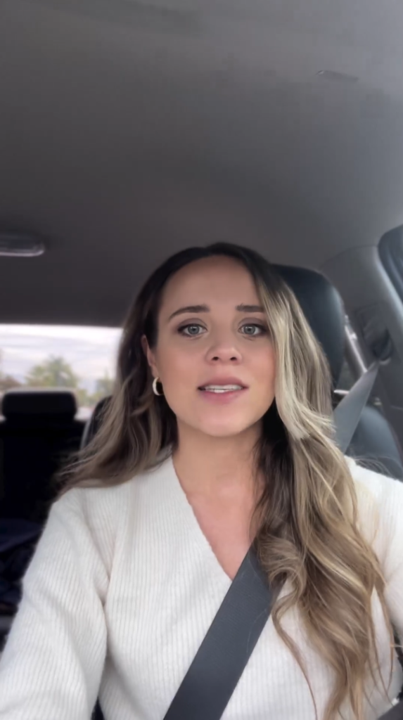 Jinger Duggar faces the phone camera while driving.