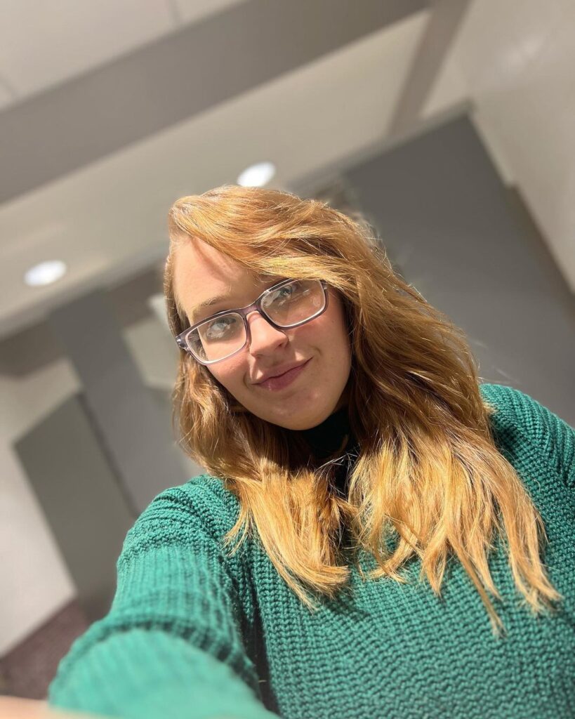 Anna Cardwell snaps this selfie in a kelly green sweater.