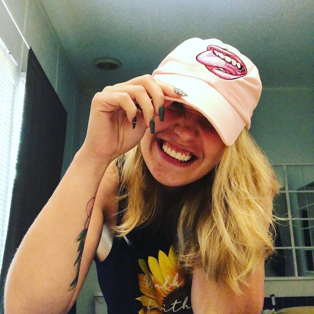 Anna Cardwell smiles while wearing a baseball cap.