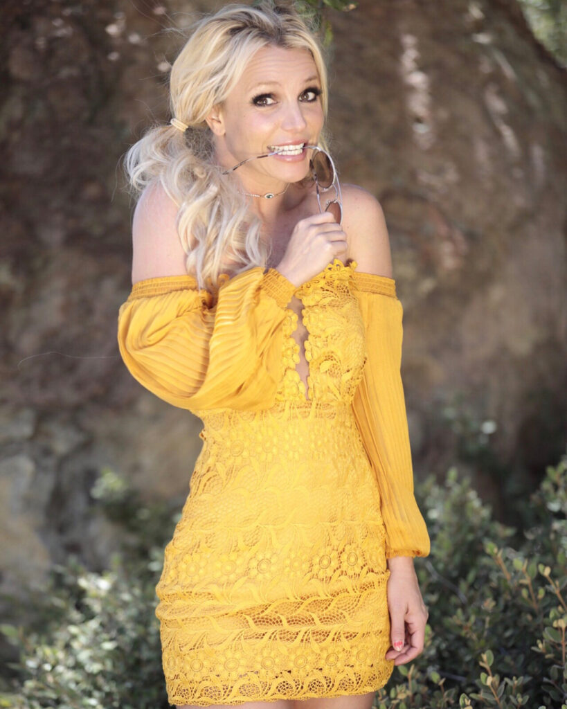 Britney Spears smiles adorably while wearing yellow.