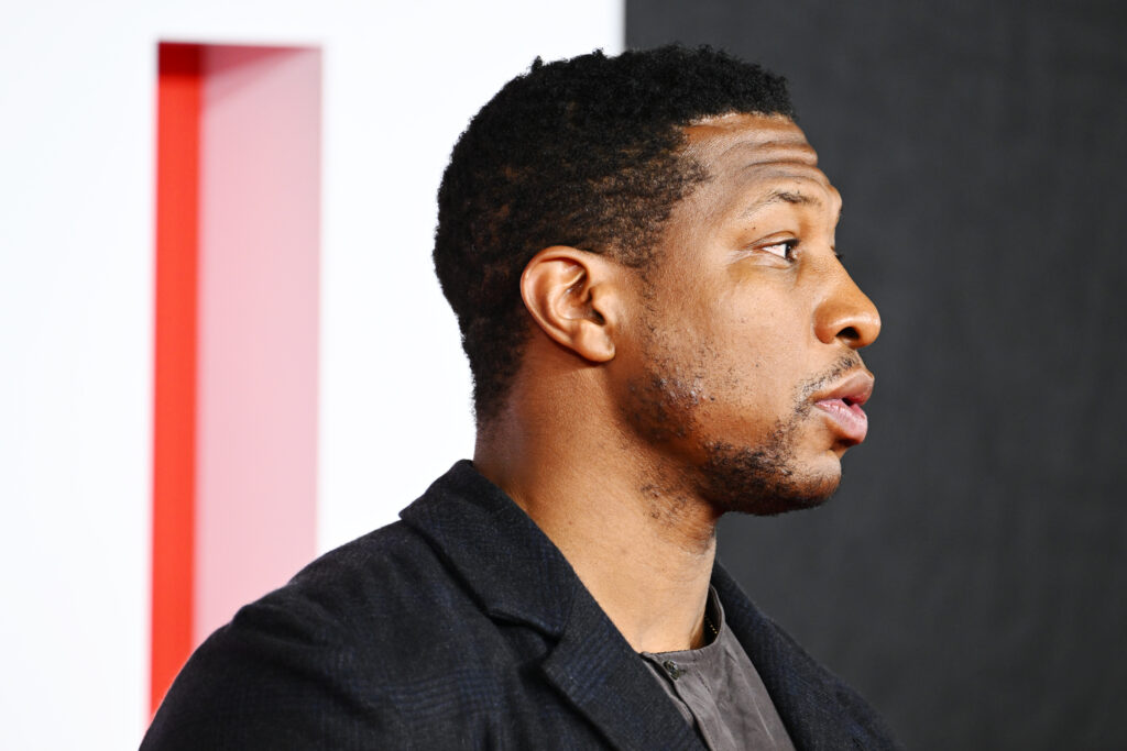 Jonathan Majors shows his profile to the camera while posing for photos.