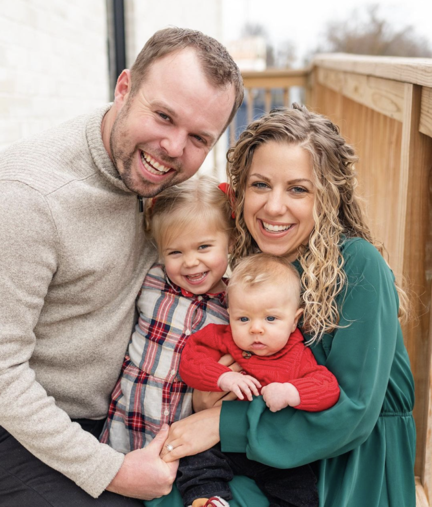 John David and Abbie Duggar pose outdoors with their children