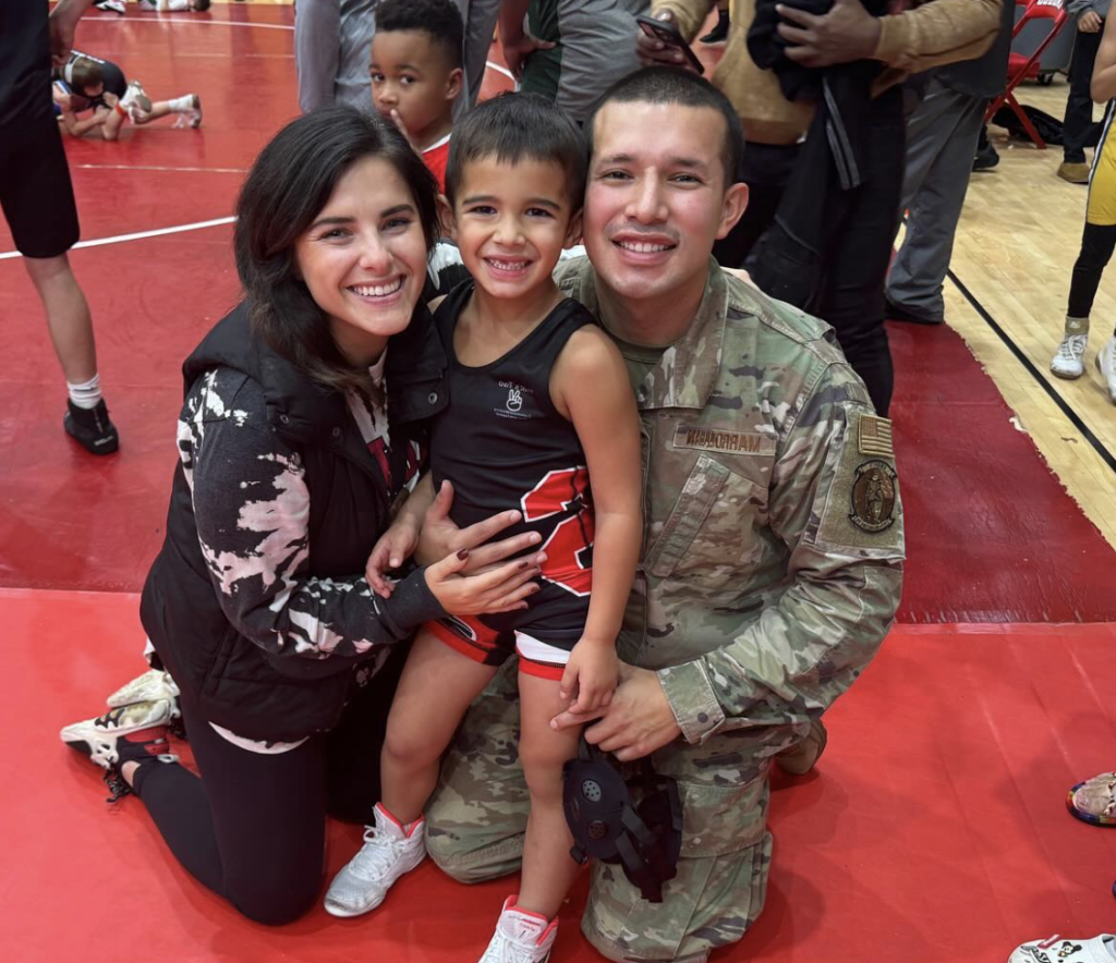 Javi Marroquin poses with his son Eli and girlfriend, Lauren Comeau, at a youth wrestling tournament.