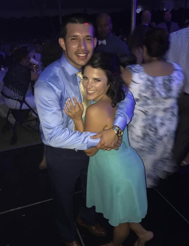 Lauren Comeau and Javi Marroquin pose on the dance floor during a wedding reception.