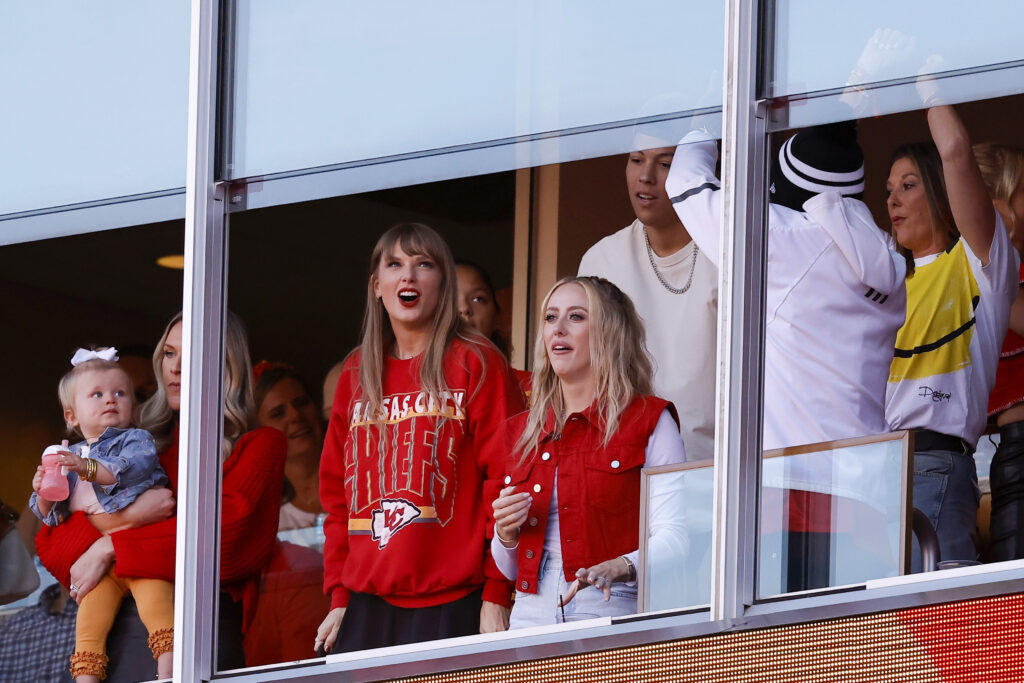 Taylor Swift and Brittany Mahomes attend a sports event.