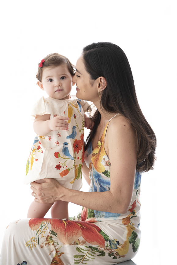 mãe beijando bebê menina smash the fruit aniversário de 1 ano de criança fotos de família no estúdio de fotografia laura alzueta em São Paulo