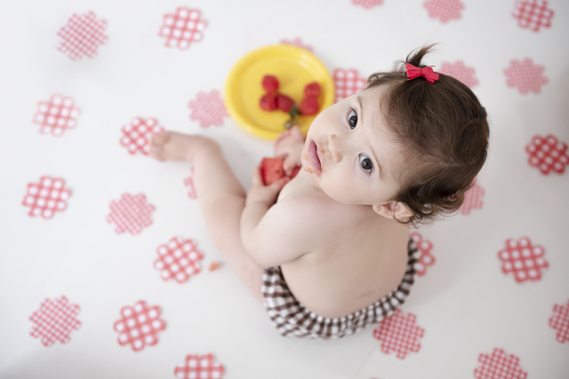bebê com fatia de melancia menina fofa fundo com balão de frutas smash the fruit aniversário de 1 ano de criança fotos de família no estúdio de fotografia laura alzueta em São Paulo