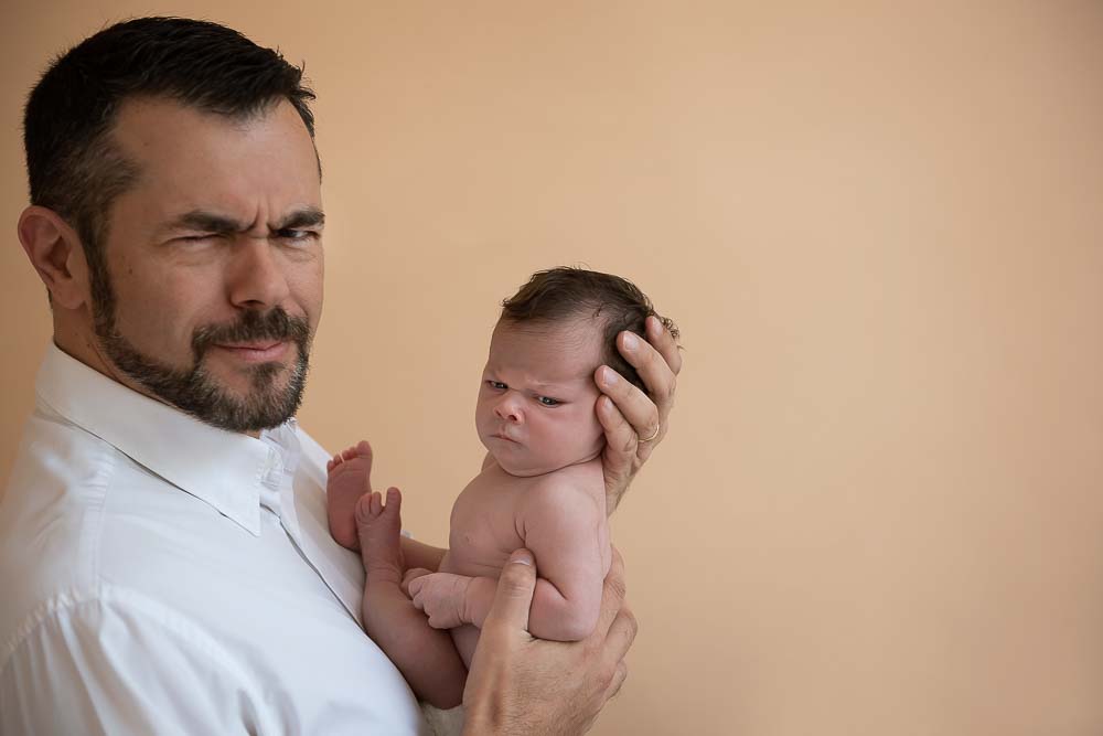 ensaio newborn: pai segurando bebê em estúdio fotográfico laura alzuera
