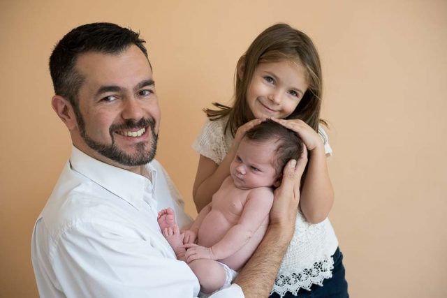 pai com recém-nascida e filha mais velha em ensaio newborn no estúdio fotográfico laura alzuera