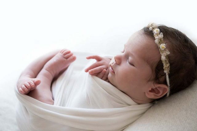 recém-nascida em em posição enrolada com wrap ensaio newborn no estúdio fotográfico laura alzueta em São Paulo