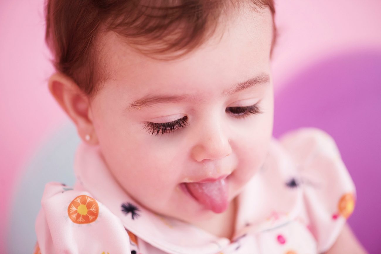 criança com língua de fora smash the cake laura alzueta estúdio de fotografia são paulo ensaio de fotos de aniversário de 1 ano de bebê menina