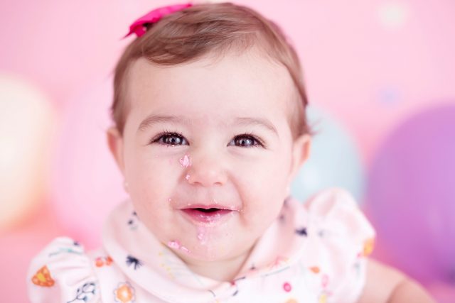 bebê fofo com laço rosa na cabeça smash the cake laura alzueta estúdio de fotografia são paulo ensaio de fotos de aniversário de 1 ano de bebê menina