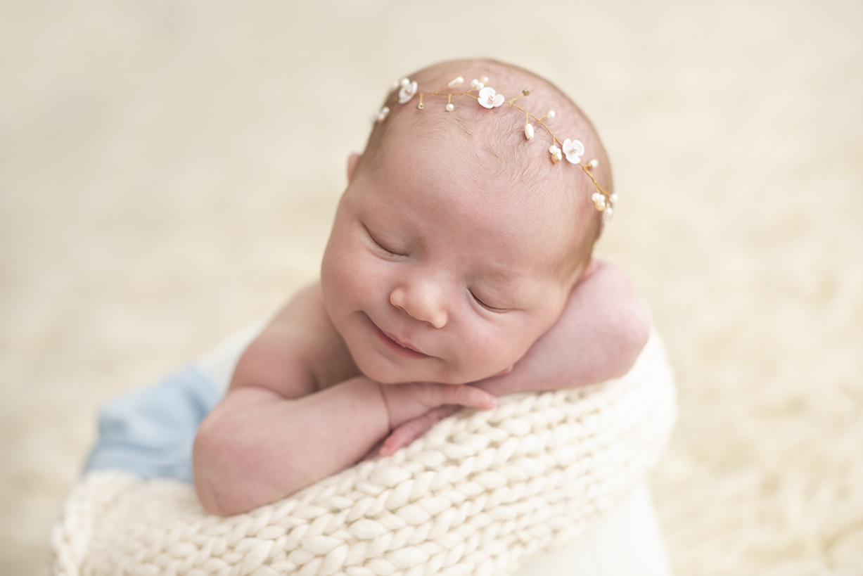 foto de menina com tiara na cabeça caretas de recém-nascidos fotos de bebê sorrindo com braços cruzados em cima de um puff no estúdio de fotos da laura alzuera zona oeste de são paulo