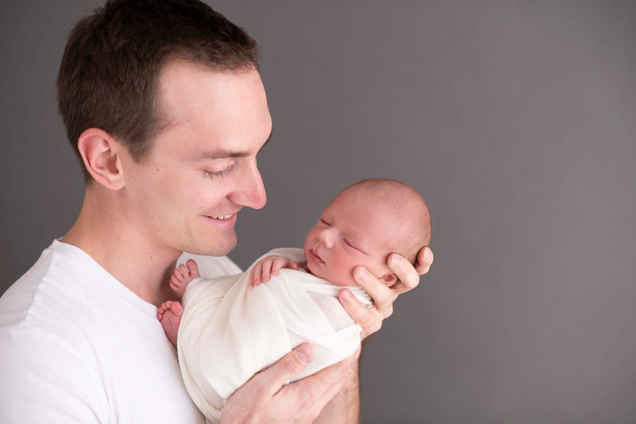 pai segura filho nas mãos fotos de ensaio newborn de menino composição fotografia laura alzueta são paulo