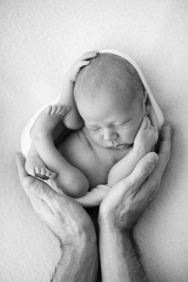 mãos dos pais segurando bebê recém nascido fotos de ensaio newborn de menino composição fotografia laura alzueta são paulo