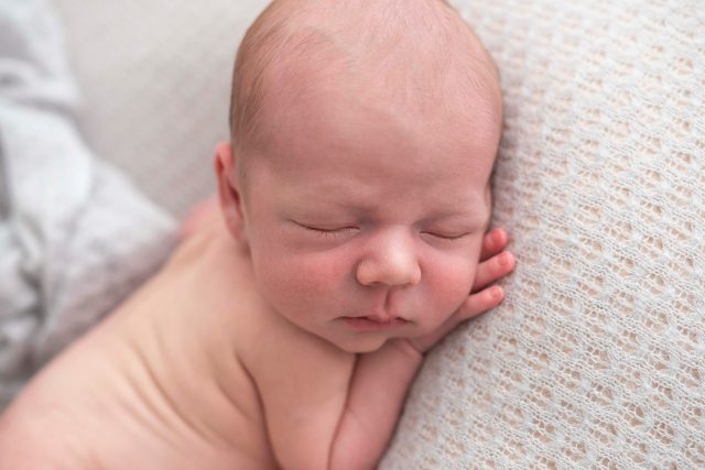 bebê com mão embaixo do rosto fotos de ensaio newborn de menino composição fotografia laura alzueta são paulo