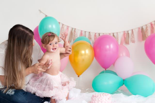 festa infantil com balões coloridos e bolo rosa smash the cake em estúdio de fotografia laura alzueta pinheiros sp fotos de primeiro ano de bebê