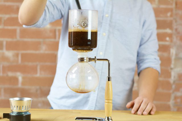 stir the coffee to brew it in the top chamber in the vaccuum coffee syphon grosche heisenberg