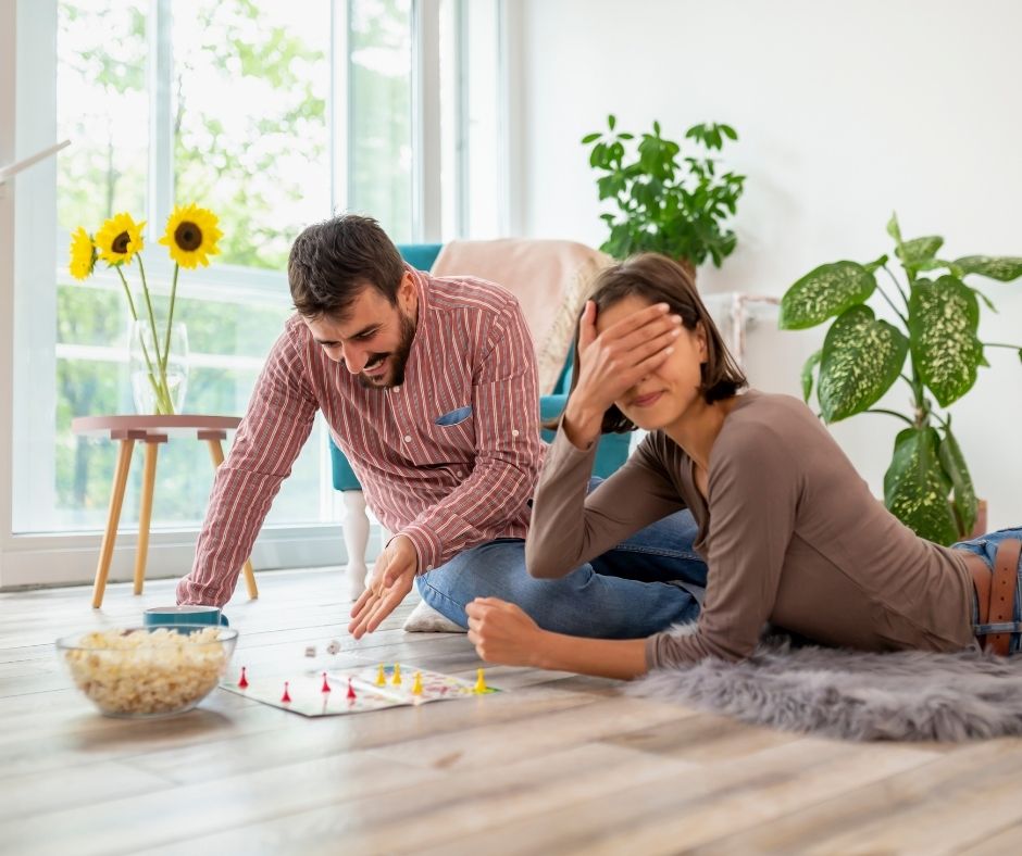 Couple playing board games together on valentine's day.