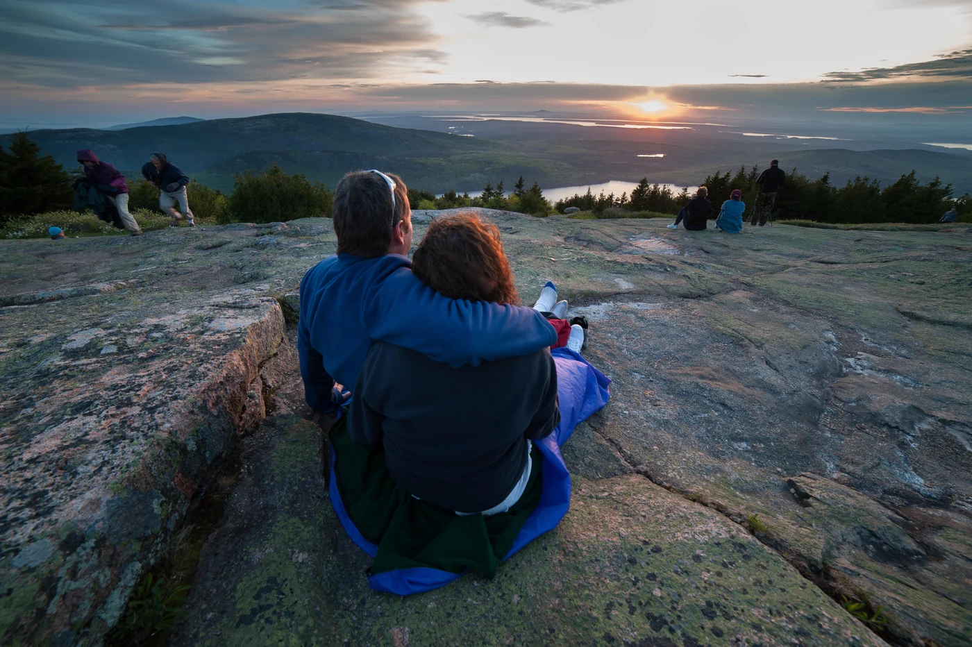Two visitors enjoy an Acadia summit overlooking the coast