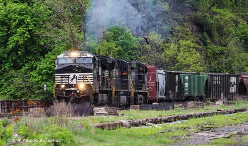 A westbound NS mixed freight throttles out, westbound, off the siding, after an eastbound intermodal passed.