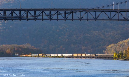 The Bear Mountain Bridge frames this view of a northbound CSX double stack train, as it crosses over the trestle at Iona Island.