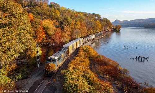 A southbound CSX mixed freight passes by the beautifully lit fall foliage, at Fort Montgomery, NY.