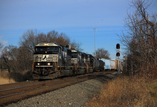 Three consecutively numbered SD60E's bring a local mixed freight through West Laurel