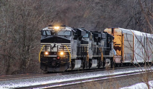 A westbound mixed freight appears from behind the bare branches at Bailey, PA.