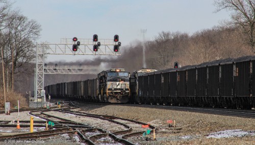 A westbound empty coal train, on the left, meets what looks like a loaded coal train. However, it is the mid-train power, of a very long mixed freight train, with a string of coal loads on the end. This was photographed at Cresson, PA.