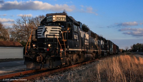 With the setting sun lower in the sky, the train returns north back to Camden. It has four boxcars, on it, that it picked up at a paper company on its trip south. Here, it is on a stretch of track that parallels Tuckahoe Road, in Dorothy, NJ.