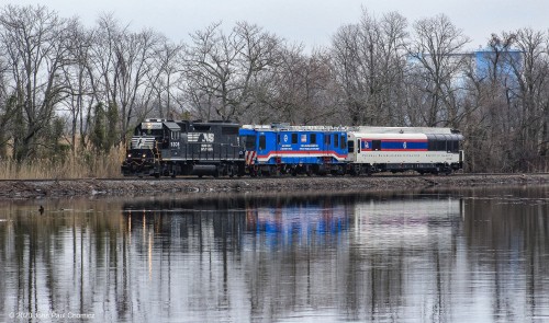 The FRA train is reflected in the water of Mantua Creek, as the train heads south, near Paulsboro, NJ.