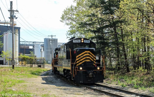 After dropping off the interchange cars at Millville, J101 proceeded further south, down the line, to switch out the Durand Glassworks. In this photograph, they are pulling out the empty hoppers. Please note that trespassing is forbidden and this plant is guarded by dangerous Black Widow spiders.