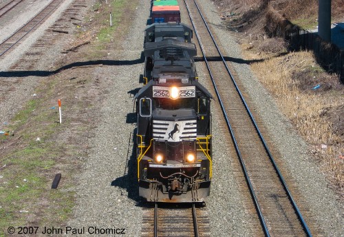 An ex-Conrail SD70 leads this hot intermodal train westbound, through downtown Cleveland, Ohio.