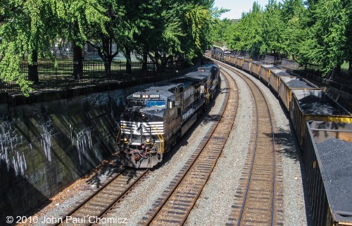 Shortly after the eastbound intermodal train, an eastbound mixed freight train passes the waiting westbound coal drag, in Allegheny Commons Park, in Pittsburgh, PA.