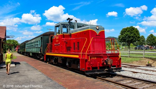 There are two ladies in this picture, the one in the red is the Wanamaker, Kempton, & Southern Railroad GE centercab #: 734, which is about to lead the excursion train out of the station, in Kempton, PA. The one in the gold is, unfortunately, just a passerby that got in the photo.