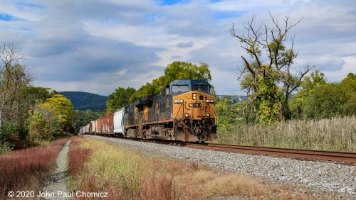 The colors of the cars, on this southbound CSX mixed freight, seem to blend well with the colors of the early autumn trees, at Tomkins Cove, NY.