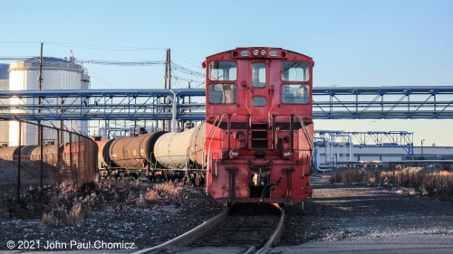 East Jersey Railroad and Terminal Company #: 321B sits near the Hook Road crossing with a string of tank cars in the late afternoon. This railroad is the in-house railroad of  International Matex Tank Terminals (IMTT), in Bayonne, NJ.