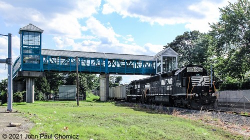 The Bayonne Yard local shoves a string of empty gondola cars south, under the pedestrian bridge at the HBLR 34th Street Station.