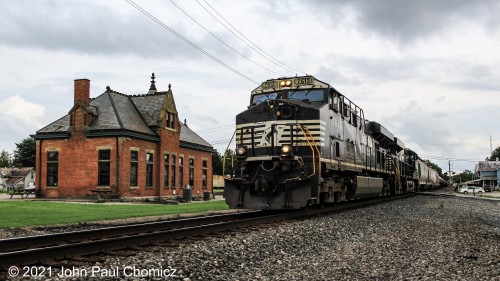 A northbound NS mixed freight train passes the Bucyrus Station Museum, on a dismal evening in Bucyrus, OH.