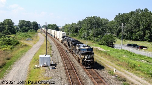 With the light still favoring eastbounds, an eastbound NS doublestack train skirts along Lake Erie, on Whiskey Island, in Cleveland, OH.