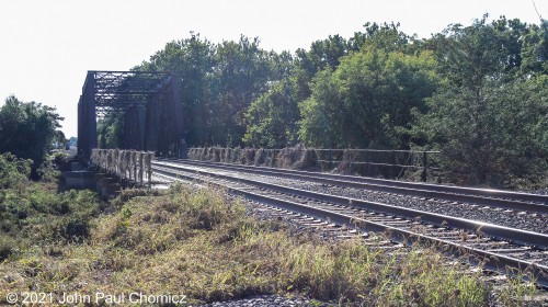 Once again, no trains in this shot. This is a photo of the railroad bridge that is still in use. Though it survived the floods, it is decorated with the debris from the flooding. It carries the double tracks of the Conrail Lehigh Line over the Raritan River in Bridgewater, NJ. This bridge is approximately twenty feet west of the destroyed bridge and it was difficult for me to believe that this bridge survived the floods, when the other bridge now resembles an amusement park roller-coaster. I don't know how this bridge survived but I was told that a train was stranded on this bridge, during the flood and that, on this day, the trains were crawling at snail's pace over this bridge. They were also stopping to flag the crossing just to the north of this location, as the crossing gates were toppled, and they had to be talked through all the signals on the line, as they were all out.