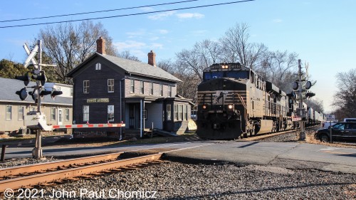 An NS intermodal train doesn't seem to be making the station stop as it passes by the Three Bridges Station in Three Bridges, NJ.