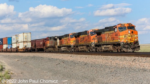 Before the eastbound intermodal cleared, a westbound covered hopper train appeared out from behind the doublestacks at Lucy, NM.