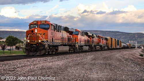 A BNSF westbound mixed freight passes through Grants, NM in the fading light of the early evening.