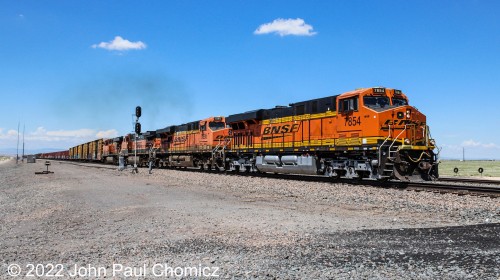 An eastbound BNSF mixed-freight train is the next to cross Route #: 47 somewhere outside of Belen, NM.