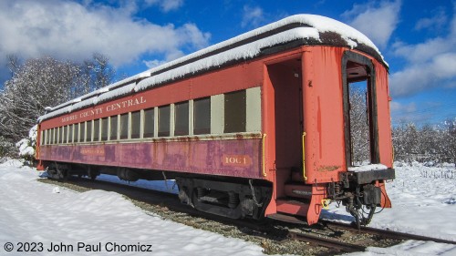 The Morris County Central Railroad coach #: 1001 started life as a CNJ coach up until passenger service on the railroad ended and it was sold to a private owner who operated it on the Morris County Central Railroad until its demise in 1980. It was then stored on this siding in Newfoundland Station where it sat until 2017, when it was donated to the Whippany Railroad Musuem. Here, it sits snow covered on the day after Thanksgiving in 2014, next to the Newfoundland Station.